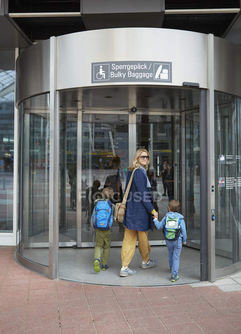 Madre e hijos caucásicos que entran en la terminal del aeropuerto, Londres, Reino Unido - foto de stock