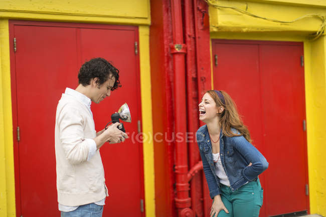 Couple en train de rire en prenant des photos — Photo de stock