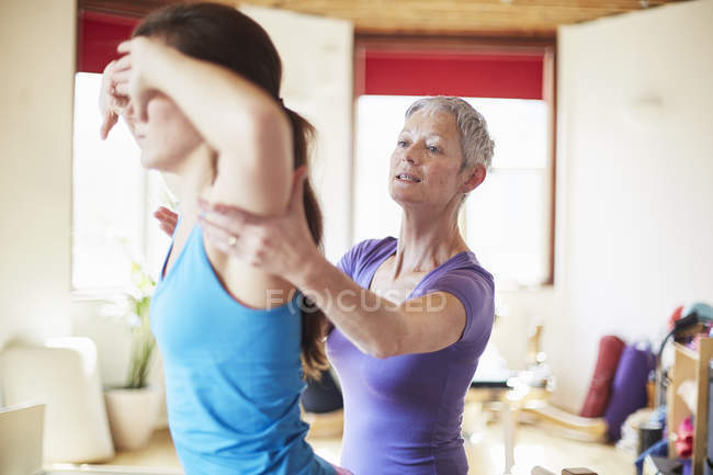 Young female student and tutor in pilates gym — Stock Photo