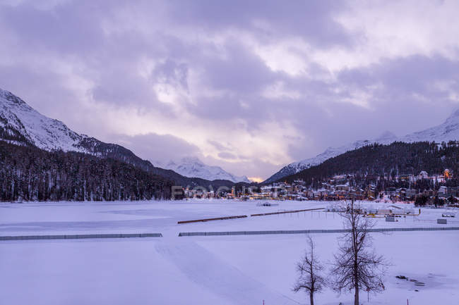 Village beneath mountain on snow covered landscape, Sankt Moritz, Switzerland — Stock Photo