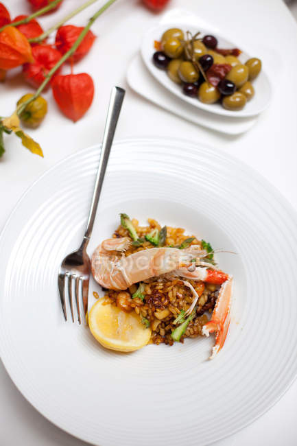 Plate of langoustine paella with olives — Stock Photo