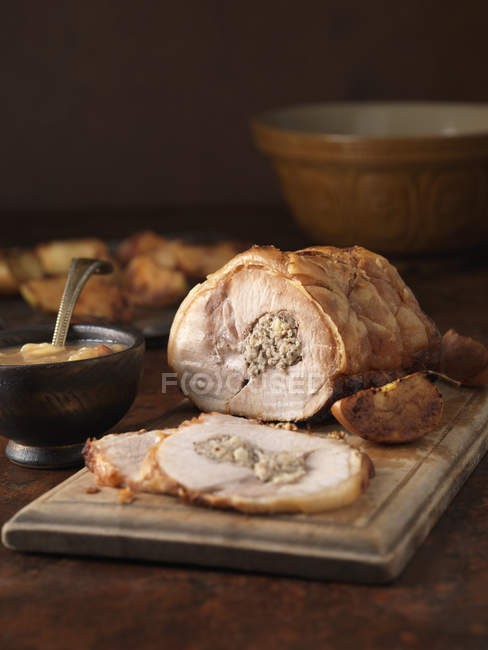 Lomo de cerdo asado con relleno y salsa en tazón - foto de stock