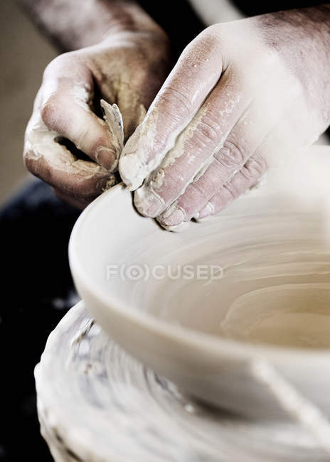 Обрезанный образ гончара, создающего чашу ручной работы в магазине — стоковое фото