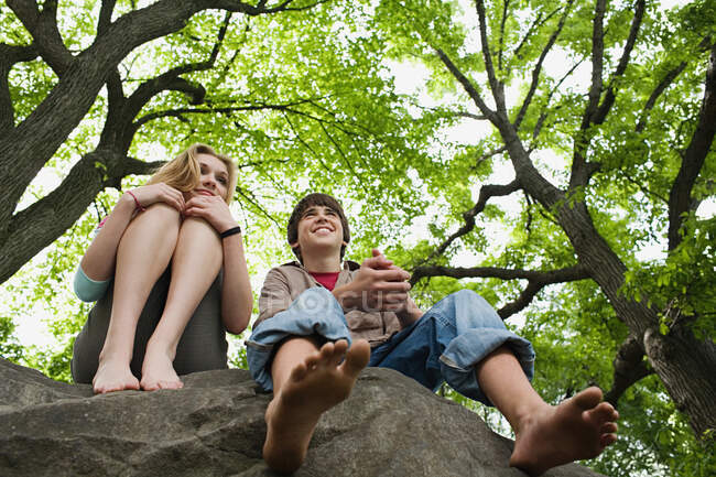 Teenagerpaar entspannt sich auf einem Felsen — Stockfoto