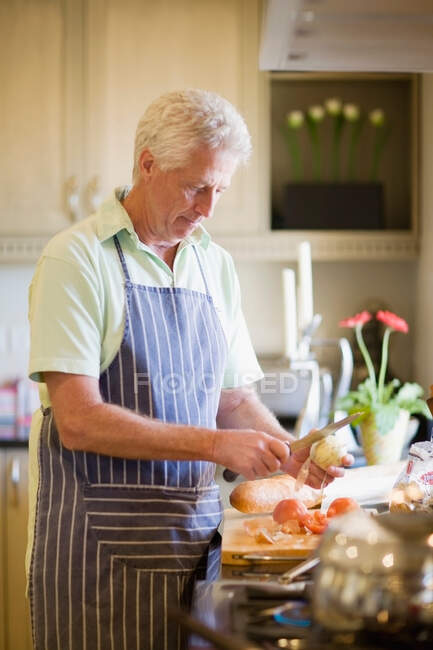Пожилой мужчина готовит на кухне — стоковое фото