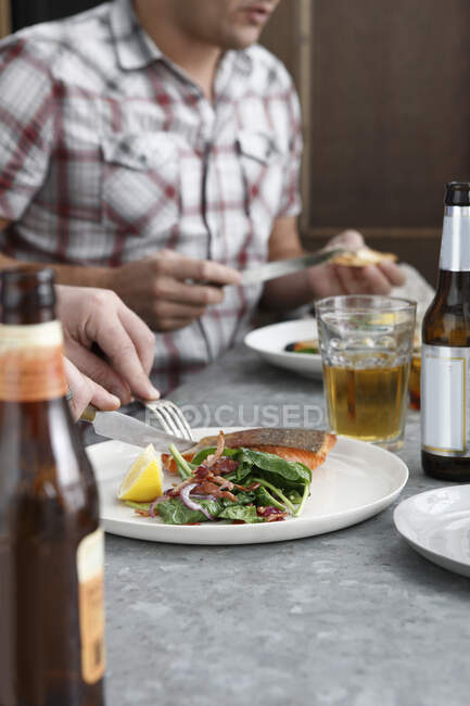 Friends enjoying meal in restaurant, mid section — Stock Photo