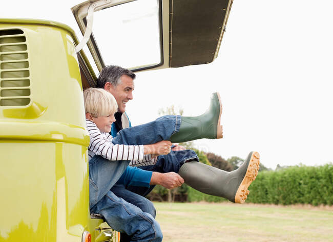 Father and son putting on boots — Stock Photo