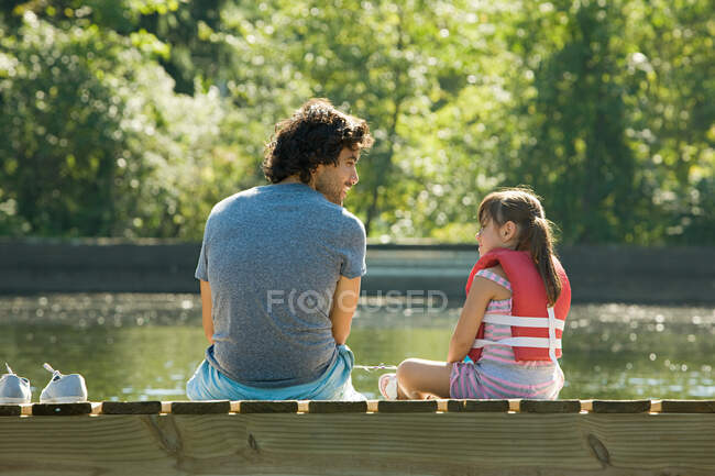 Pai e filha no molhe no lago — Fotografia de Stock
