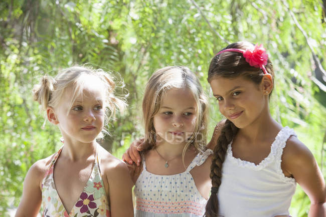 Candid portrait of three girls in garden — Stock Photo