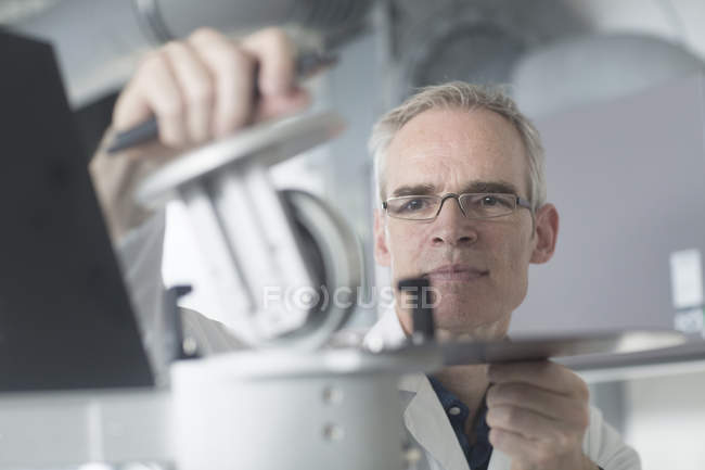 Чоловічий метеоролог спостерігає за метеорологічним обладнанням на даху метеорологічної станції — стокове фото