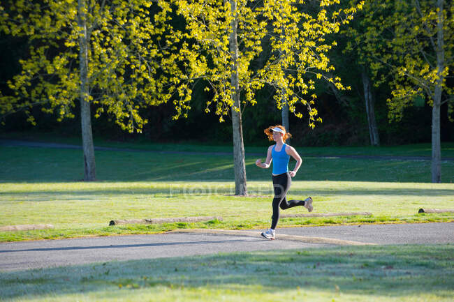 Teenage girl jogging in park — Stock Photo