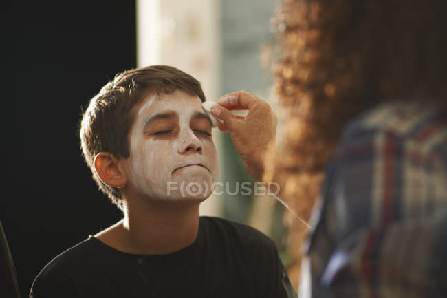 Mother painting son face white for Halloween — Stock Photo