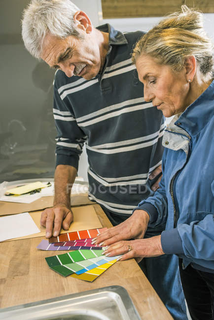 Coppia anziana con cartelle colori — Foto stock