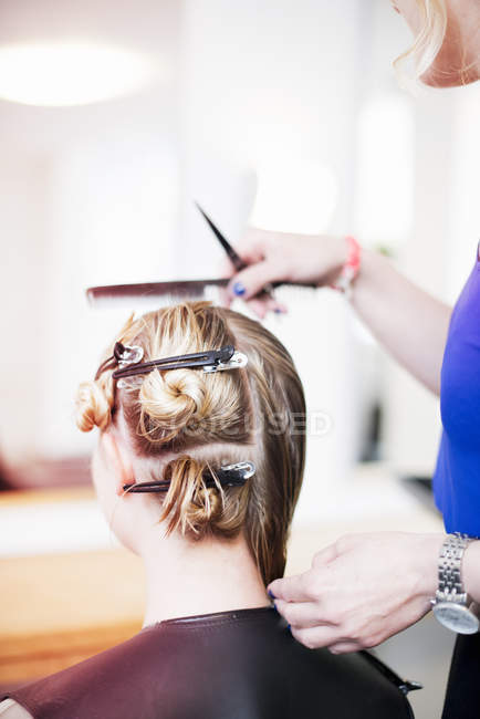 Женщина с заколками в волосах в салоне — стоковое фото