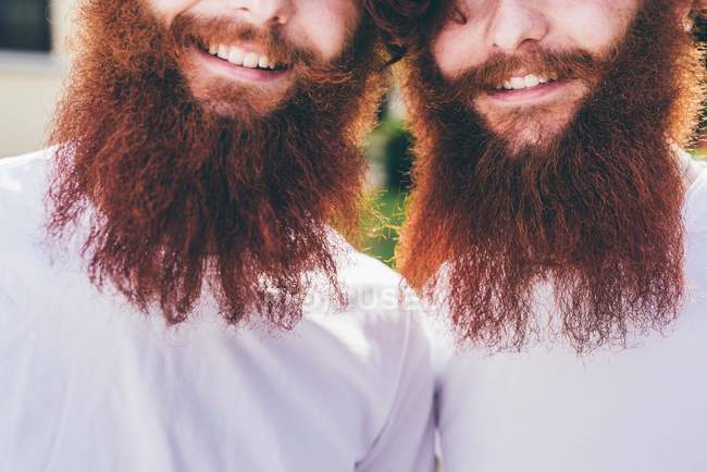 Portrait recadré de jeunes jumeaux hipster mâles à barbe rouge portant des t-shirts blancs — Photo de stock