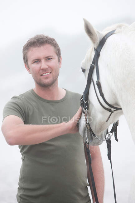 Человек с лошадью на пляже — стоковое фото