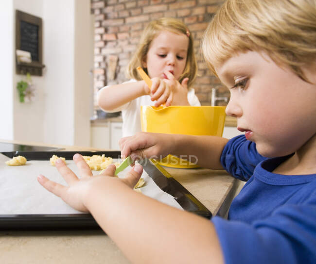 Menina, menino que prepara bolinhos para o cozimento — Fotografia de Stock