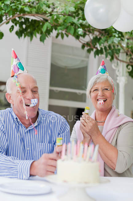 Pareja mayor riendo en fiesta de cumpleaños - foto de stock
