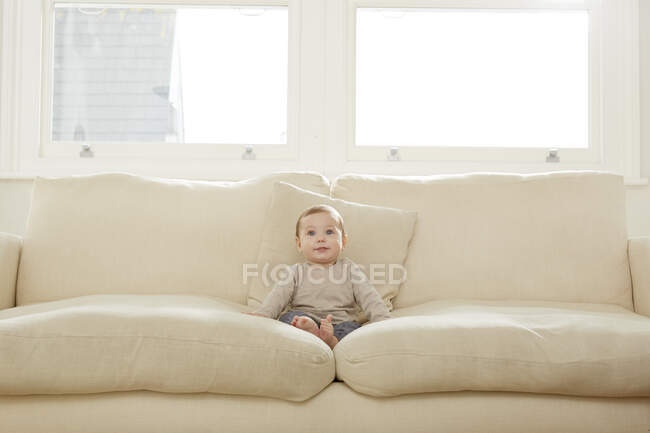 Portrait de bébé garçon assis sur le canapé — Photo de stock