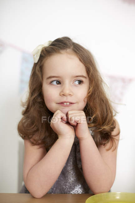 Menina com dentes de coelho sonhando acordado à mesa — Fotografia de Stock