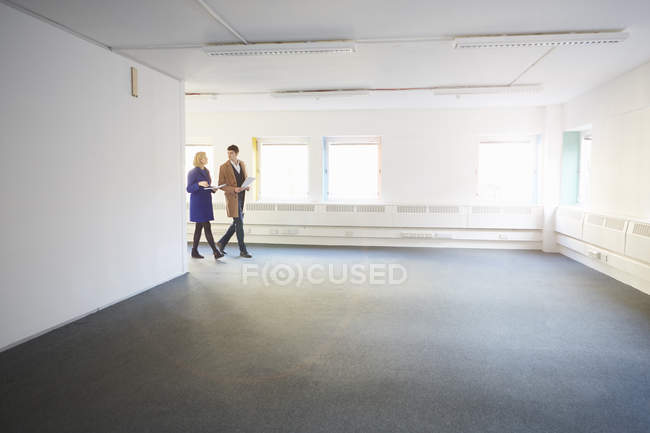 Colegas caminhando pelo escritório vazio — Fotografia de Stock