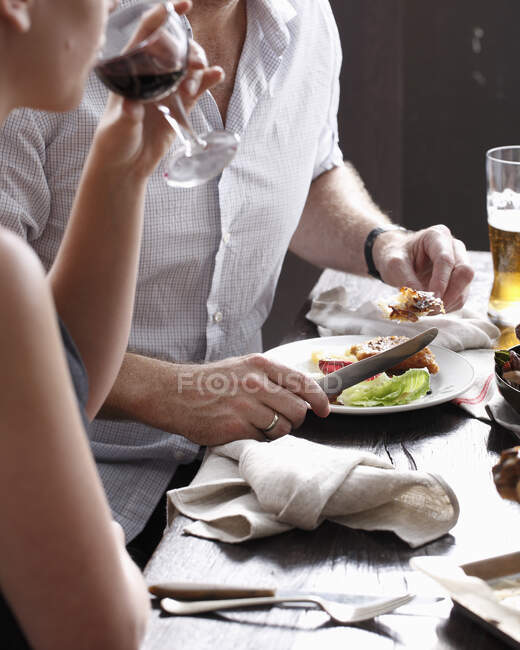 Two people eating and drinking in restaurant, mid section — Stock Photo