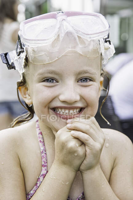 Girl with goggles on head clasping hands — Stock Photo