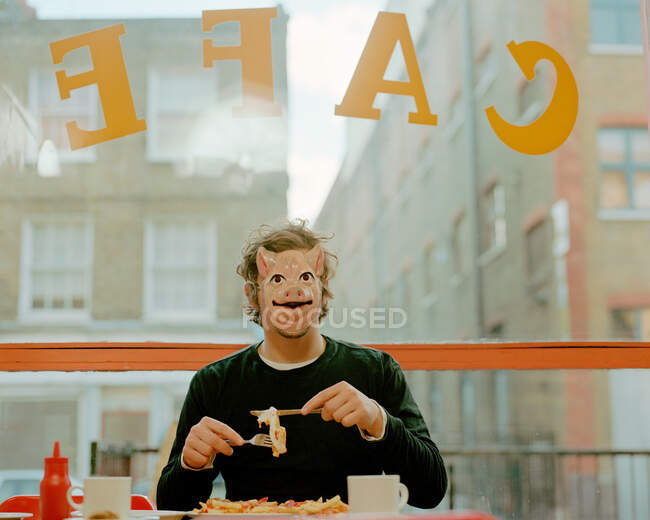 Чоловік в масці для обличчя в кафе — стокове фото