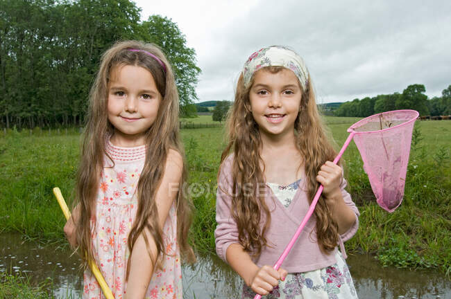 Sisters fishing by the river — Stock Photo