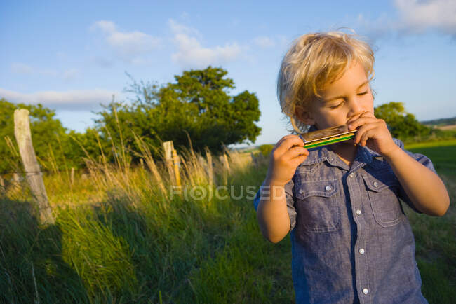 A boy playing the harmonica — Stock Photo