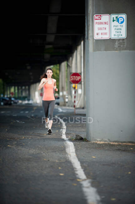 Женщина бежит по городской улице — стоковое фото