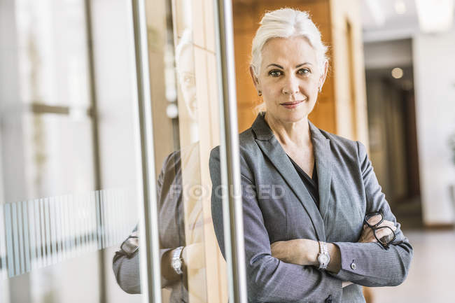 Geschäftsfrau verschränkt die Arme und blickt in die Kamera — Stockfoto