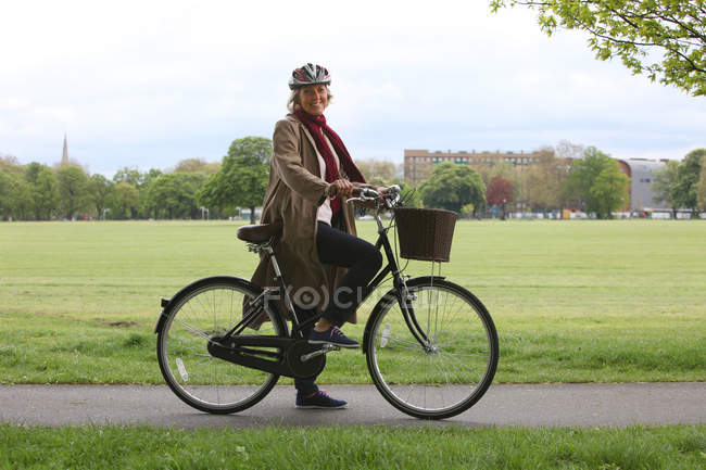 Старшая женщина на велосипеде в парке, портрет — стоковое фото