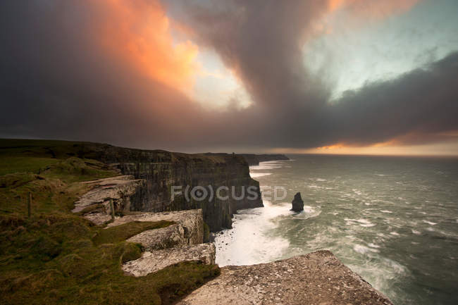 Colorful clouds over coastal cliffs — Stock Photo