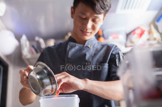 Chef asiático en cocina comercial preparando comida - foto de stock