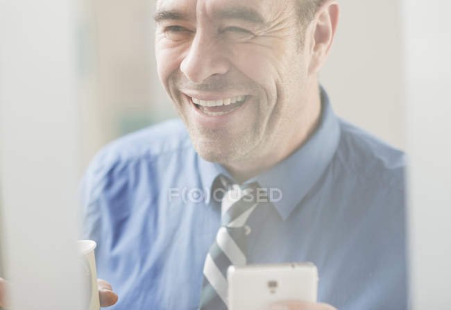 Зрілий бізнесмен сміється в офісі — стокове фото