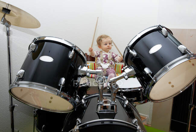 Bebé niña jugando batería - foto de stock