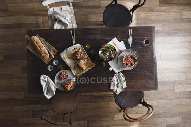 Schweinshaxen, Salat und frisches Brot auf Restauranttisch, von oben — Stockfoto