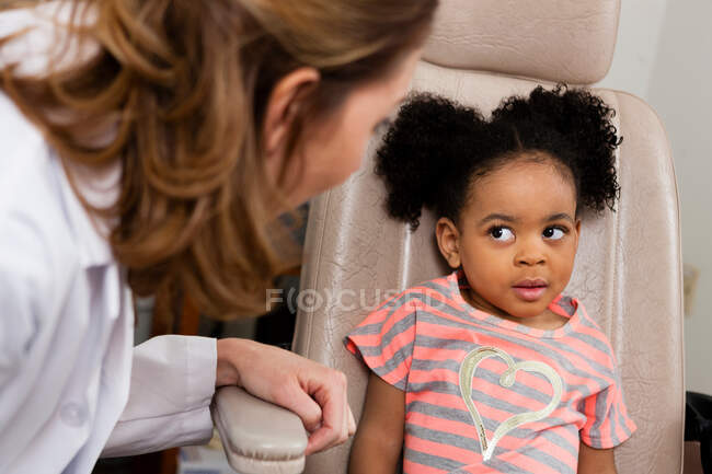 Médico adulto medio hablando con paciente joven - foto de stock