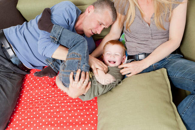 Familie spielt zusammen auf Sofa — Stockfoto