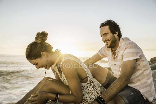 Mittleres erwachsenes Paar lacht am Strand bei Sonnenuntergang, Kapstadt, Südafrika — Stockfoto