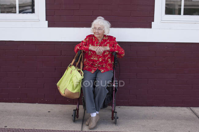 Пожилая женщина, сидящая в инвалидной коляске, на улице — стоковое фото