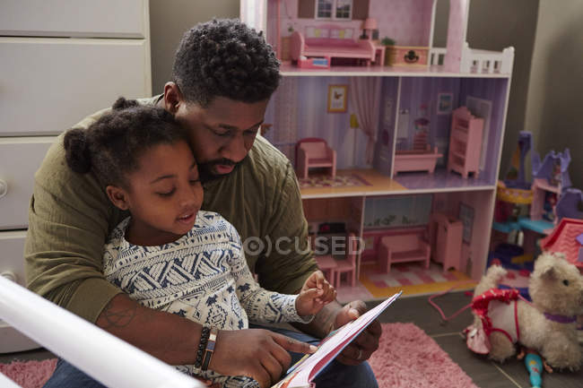 Отец читает дочери — стоковое фото