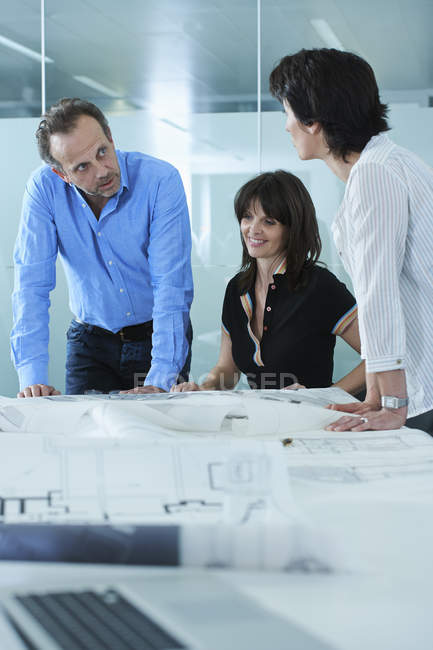 Архитекторы отображают чертежи клиентов на столе в зале заседаний — стоковое фото