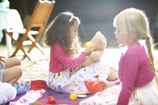 Girls playing picnics at garden birthday party — Stock Photo