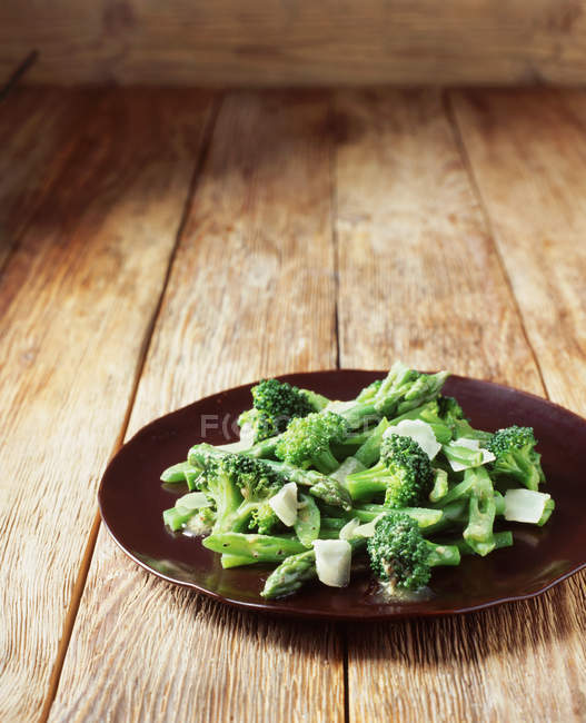 Broccoli, asparagus and green beans with shaved parmesan on plate — Stock Photo
