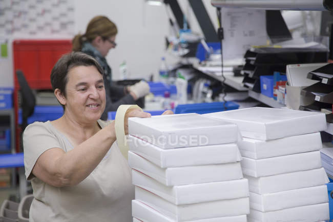 Trabajadoras empacando cajas en almacén de salud - foto de stock