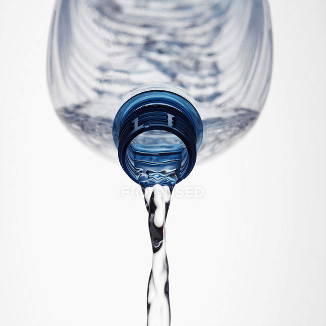 Acqua che fuoriesce dalla bottiglia di plastica, colpo da vicino — Foto stock