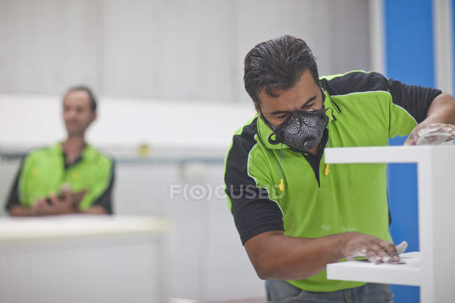 Man sanding wood products in carpenters workshop — Stock Photo