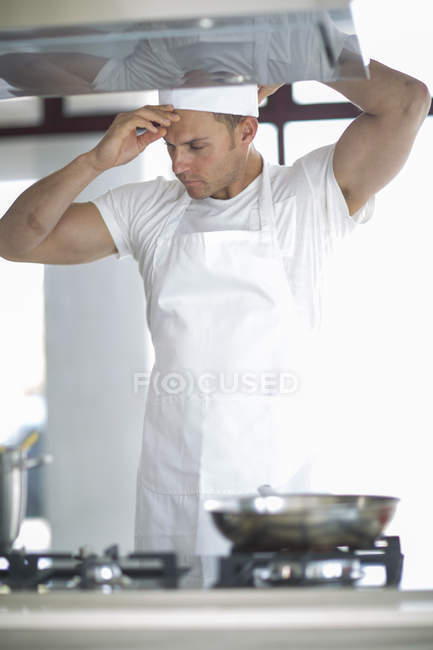Chef masculino ajustando tapa en cocina comercial - foto de stock